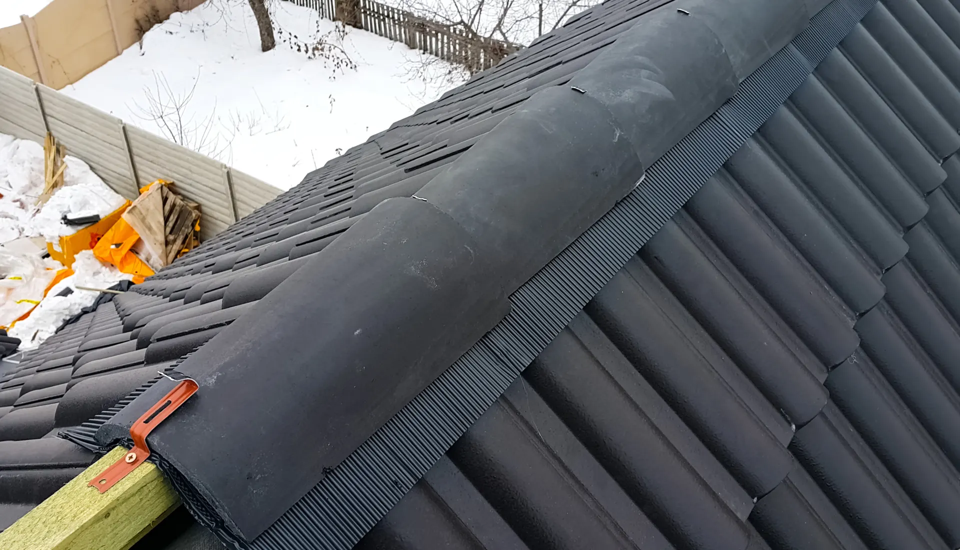 A dry ridge cap being fitted along a tiled roof