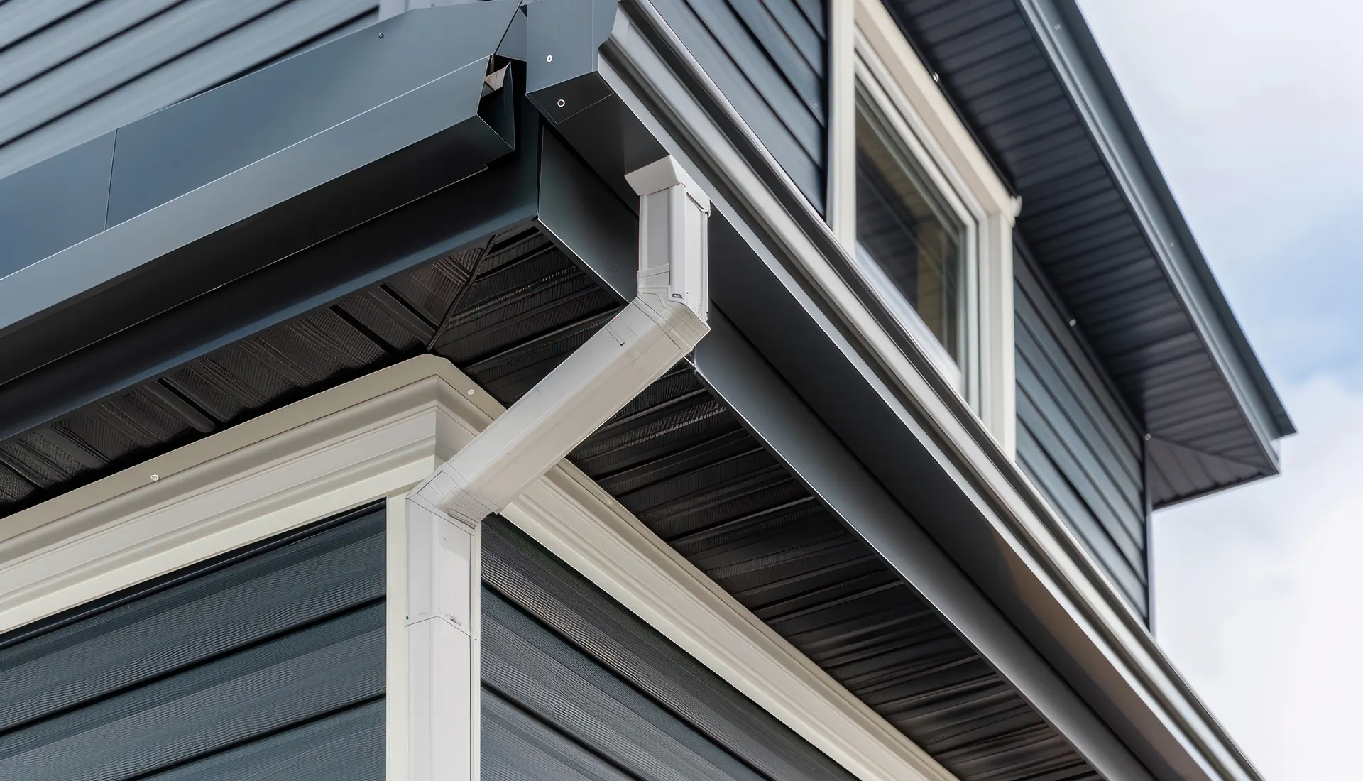 Grey fascia boards and white guttering on a clad house