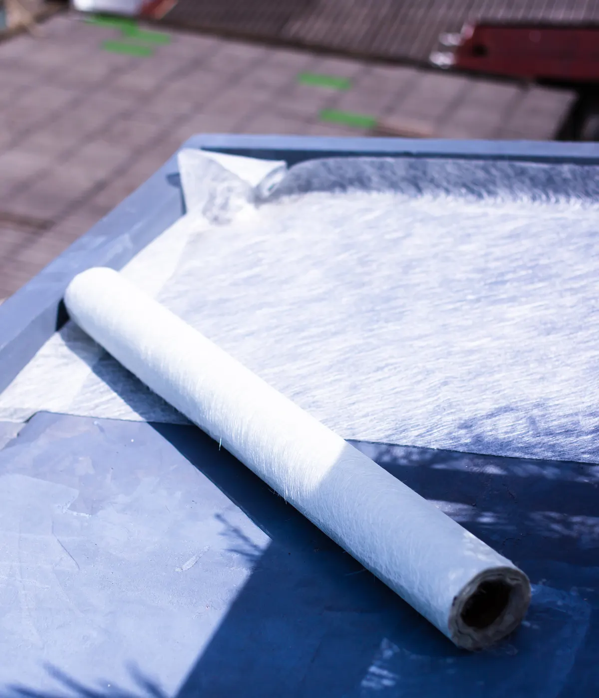 Fibreglass matting rolled out on a flat roof deck