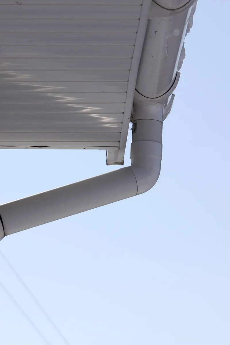 A white downpipe running from the gutter