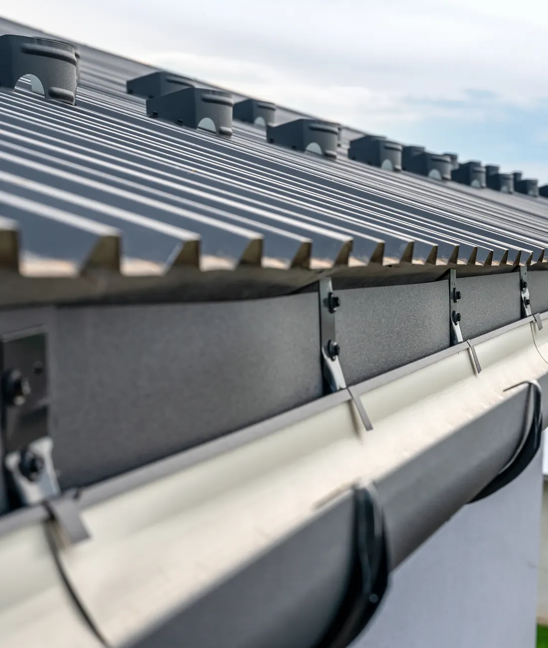 Black guttering on brackets along a roof edge