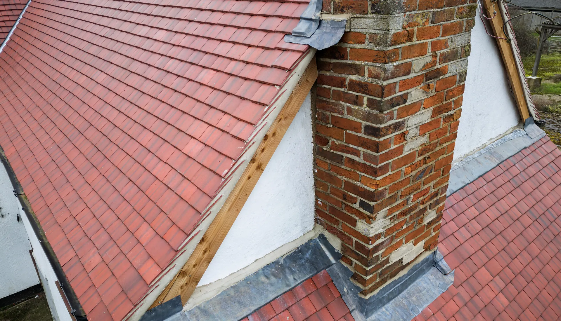 Lead flashing around a brick chimney on a clay tiled roof
