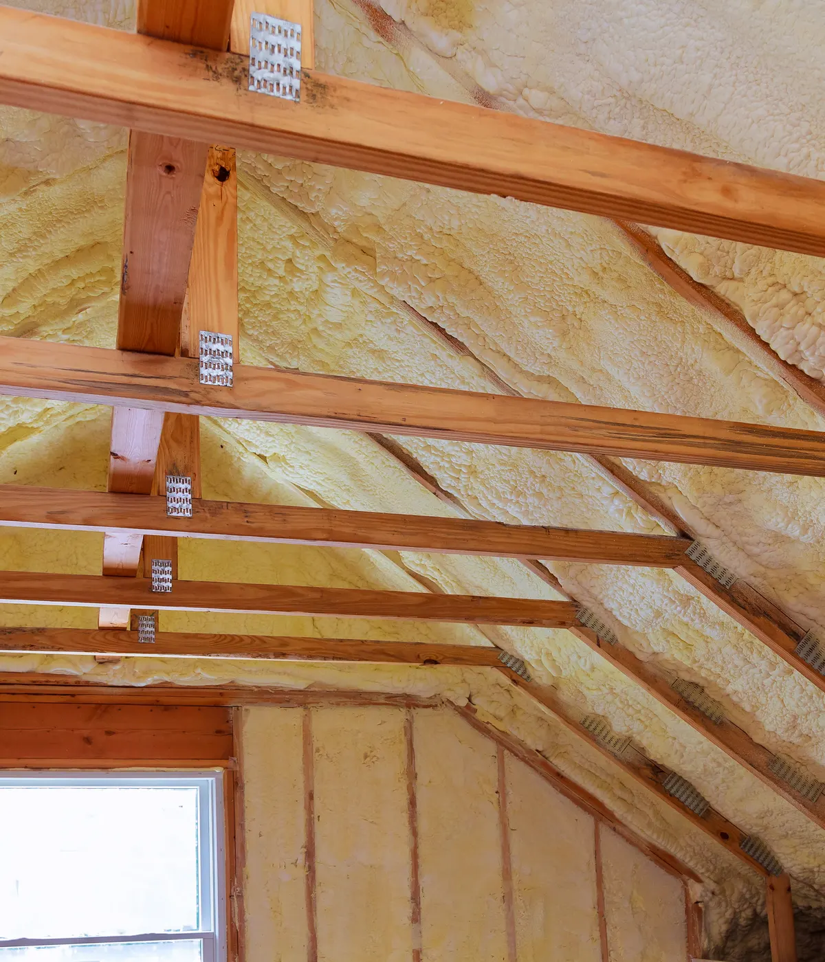 Spray foam across the underside of a roof above a loft window