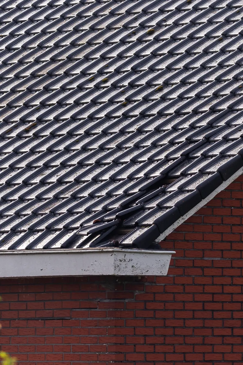 Dark interlocking tiles on a brick house