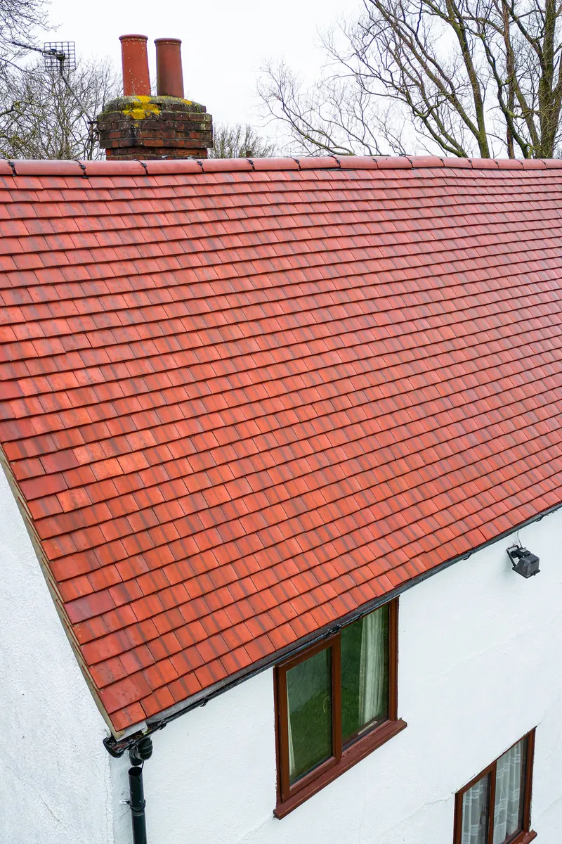 A clay tiled roof on a white-walled house